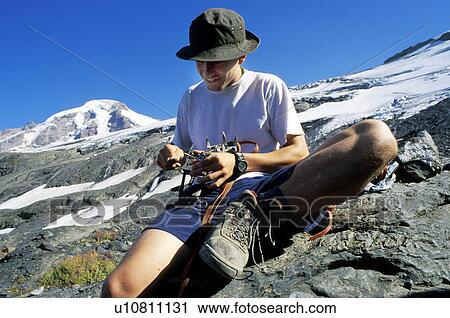 Mountaineer checking equipment View Large Photo Image Stock Image - Mountaineer checking equipment. Fotosearch