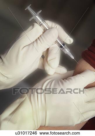 Stock Photograph - Patient receiving injection in arm. Fotosearch