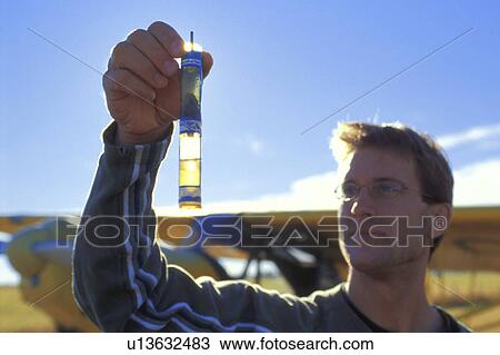 Stock Image - Pilot checking fluid levels. Fotosearch