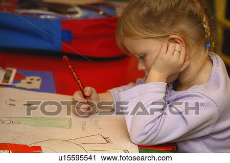 Stock Image - Preschool age girl drawing pictures in kindergarten class. Fotosearch