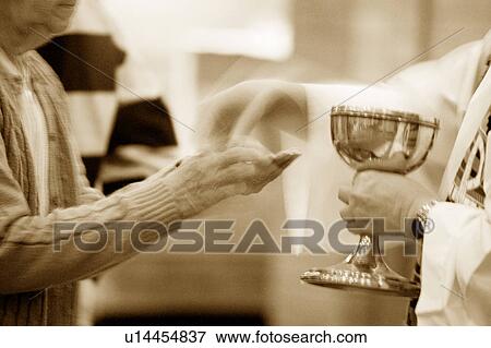 Priest handing over communion wafer View Large Photo Image Stock Photo - Priest handing over communion wafer. Fotosearch