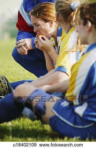 Stock Photo - Soccer players sit on grass. Fotosearch