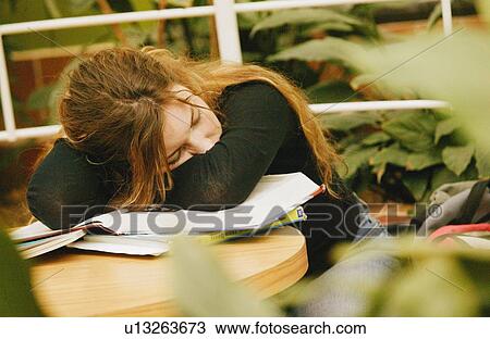 Stock Image - Student naps on books. Fotosearch