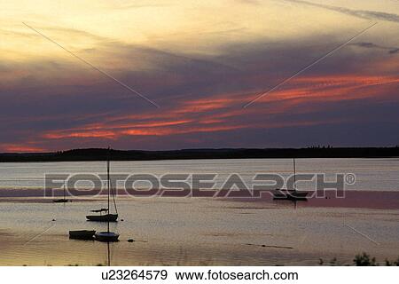 Stock Photo - Sunset over large expanse of water. Fotosearch