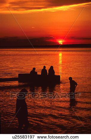 Stock Photo - Sunset over water on the pier. Fotosearch