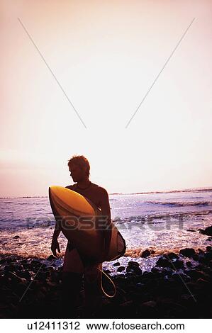 Surfer carrying surfboard View Large Photo Image Stock Image - Surfer carrying surfboard. Fotosearch