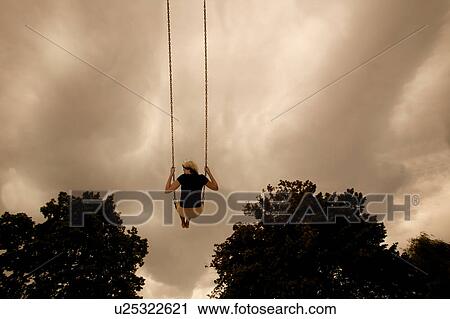 Stock Image - Swinging on a swing. Fotosearch