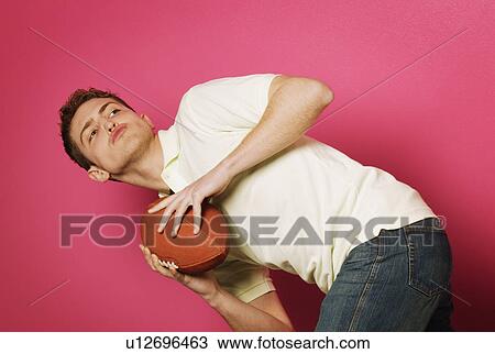 Stock Image - Teen holding football. Fotosearch