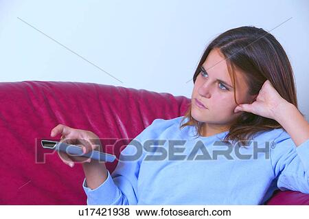 Teen with TV remote View Large Photo Image Stock Photo - Teen with TV remote. Fotosearch