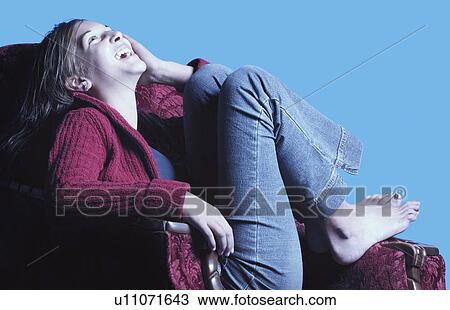 Stock Image - Teenage girl in armchair. Fotosearch