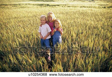 Stock Photo - Three children standing in a field of wheat. Fotosearch