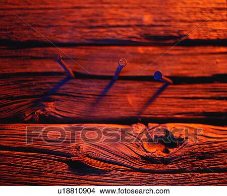 Three nails in wood in red tones View Large Photo Image Picture - Three nails in wood in red tones. Fotosearch