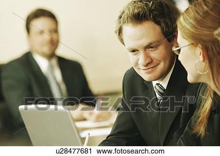 Stock Image - Three people at a business meeting. Fotosearch
