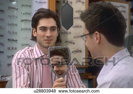 Stock Photo - Trying on glasses. Fotosearch