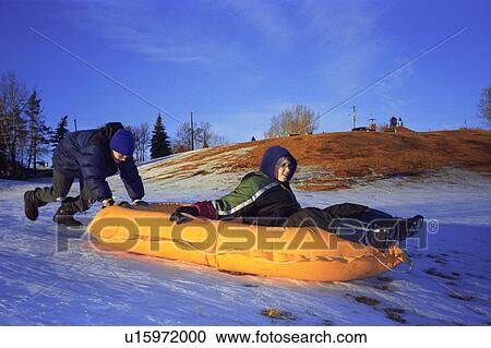 Two boys push a raft down a hill View Large Photo Image Stock Image - Two boys push a raft down a hill. Fotosearch