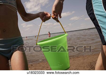 Two children carrying bucket View Large Photo Image Stock Image - Two children carrying bucket. Fotosearch