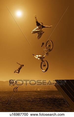 Two cyclists jumping off ramp into water View Large Photo Image Stock Image - Two cyclists jumping off ramp into water. Fotosearch