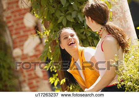 Stock Photo - Two girls share a joke. Fotosearch