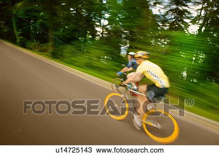 Two people racing on bikes View Large Photo Image Stock Image - Two people racing on bikes. Fotosearch