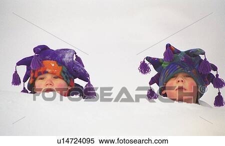 Stock Photography - Two toddlers buried up to their necks in snow. Fotosearch