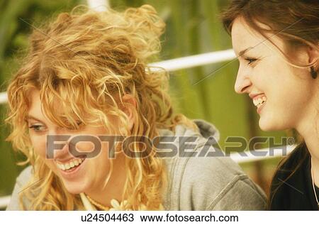 Stock Image - Two women laugh together. Fotosearch