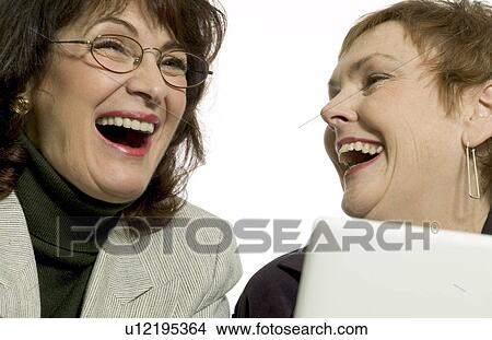 Picture - Two women sharing a joke. Fotosearch