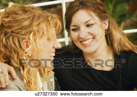 Two women sharing a laugh View Large Photo Image Stock Image - Two women sharing a laugh. Fotosearch
