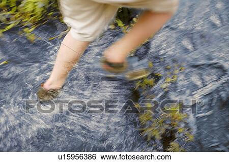 Stock Photograph - Walking through the water. Fotosearch