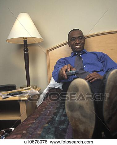 Stock Photograph - Watching tv in hotel room. Fotosearch