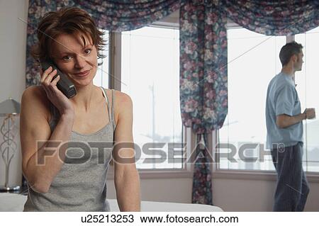 Wife chats on phone while husband waits View Large Photo Image Stock Image - Wife chats on phone while husband waits. Fotosearch