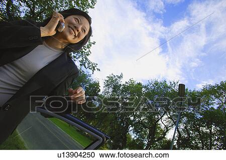 Stock Image - Woman has conversation on cell phone. Fotosearch