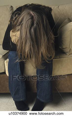 Stock Image - Woman hiding in a cushion. Fotosearch