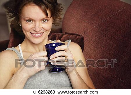 Stock Image - Woman holding coffee. Fotosearch