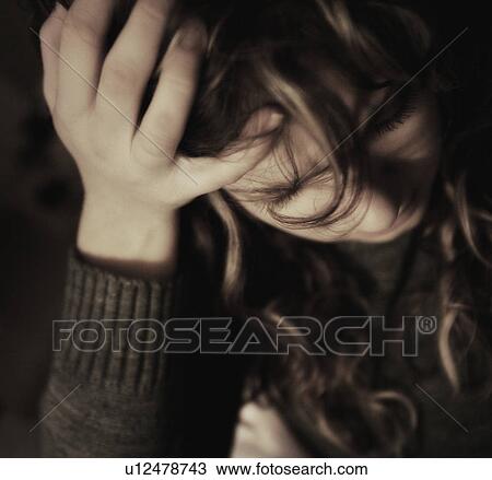 Stock Image - Woman holding head in hand. Fotosearch