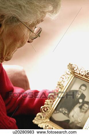Stock Image - Woman holds a photo. Fotosearch