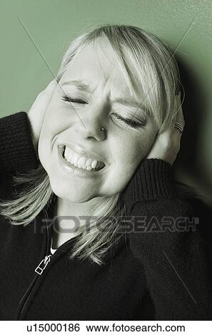 Stock Photograph - Woman holds hands over her ears. Fotosearch