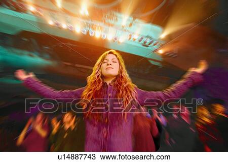 Stock Image - Woman in a worship service. Fotosearch