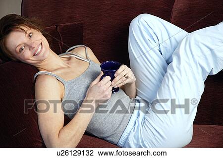 Woman laying on sofa View Large Photo Image Stock Image - Woman laying on sofa. Fotosearch