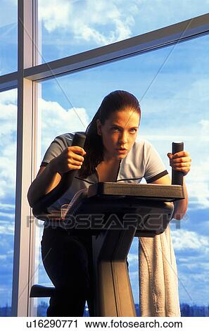 Stock Image - Woman on exercise bicycle. Fotosearch