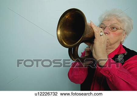 Stock Image - Woman plays horn. Fotosearch