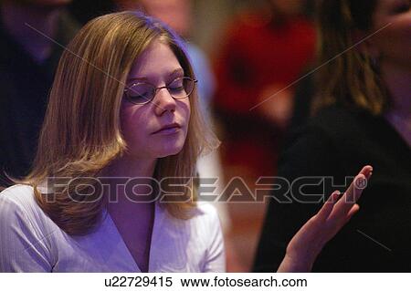 Stock Photography - Woman raising hand in worship. Fotosearch