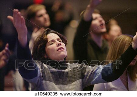 Stock Photography - Woman raising hands in worship. Fotosearch