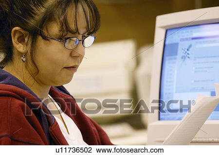 Stock Image - Woman reads paper. Fotosearch