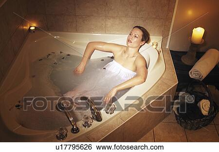 Stock Photograph - Woman relaxing in hot tub. Fotosearch