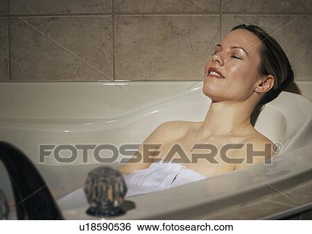 Stock Photograph - Woman relaxing in hot tub. Fotosearch