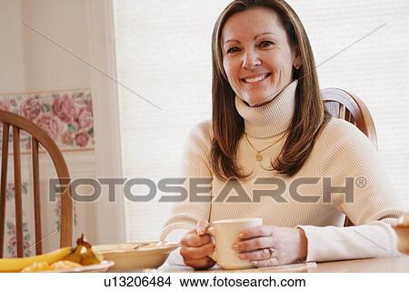 Picture - Woman smiles with cup of coffee. Fotosearch