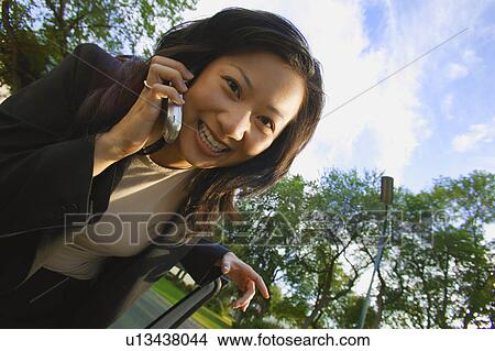 Picture - Woman talks on cell phone. Fotosearch