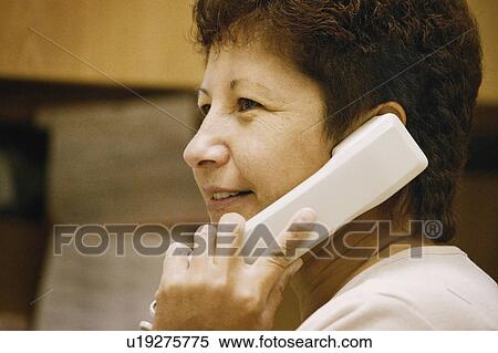 Stock Photography - Woman talks on telephone. Fotosearch