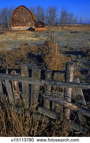 Stock Image - Wooden fence with old barn in background. Fotosearch