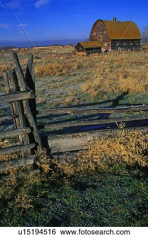 Stock Photograph - Wooden fence with old barn in background. Fotosearch